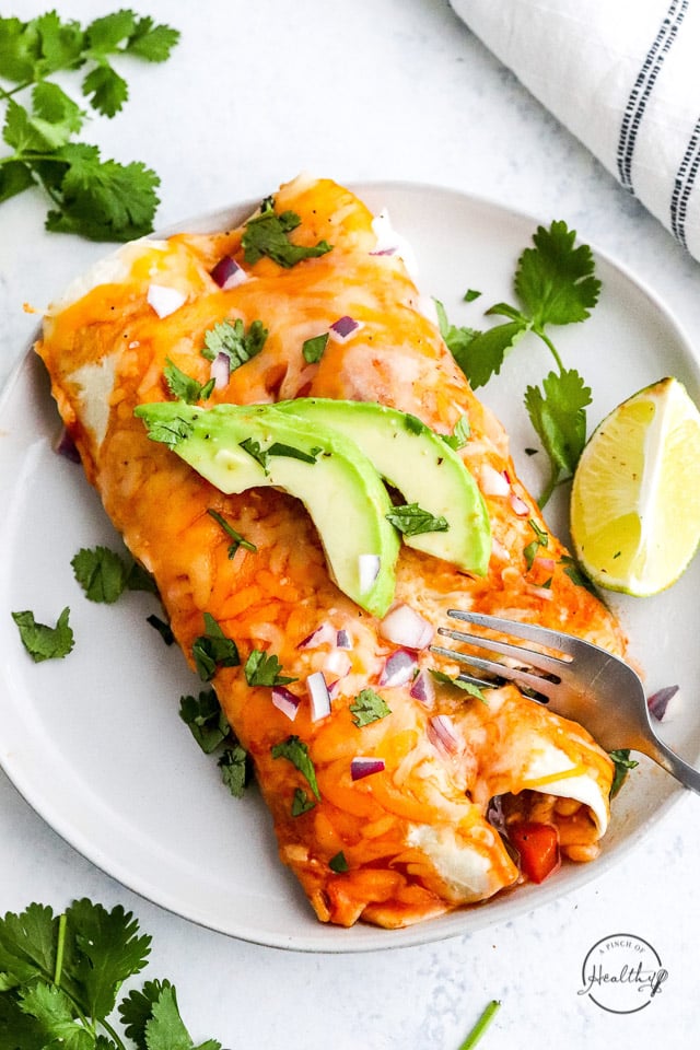 fork cutting into a bite of vegetarian enchiladas