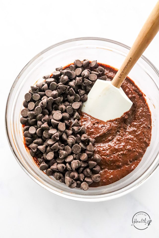 folding in chocolate chips to vegan brownies batter