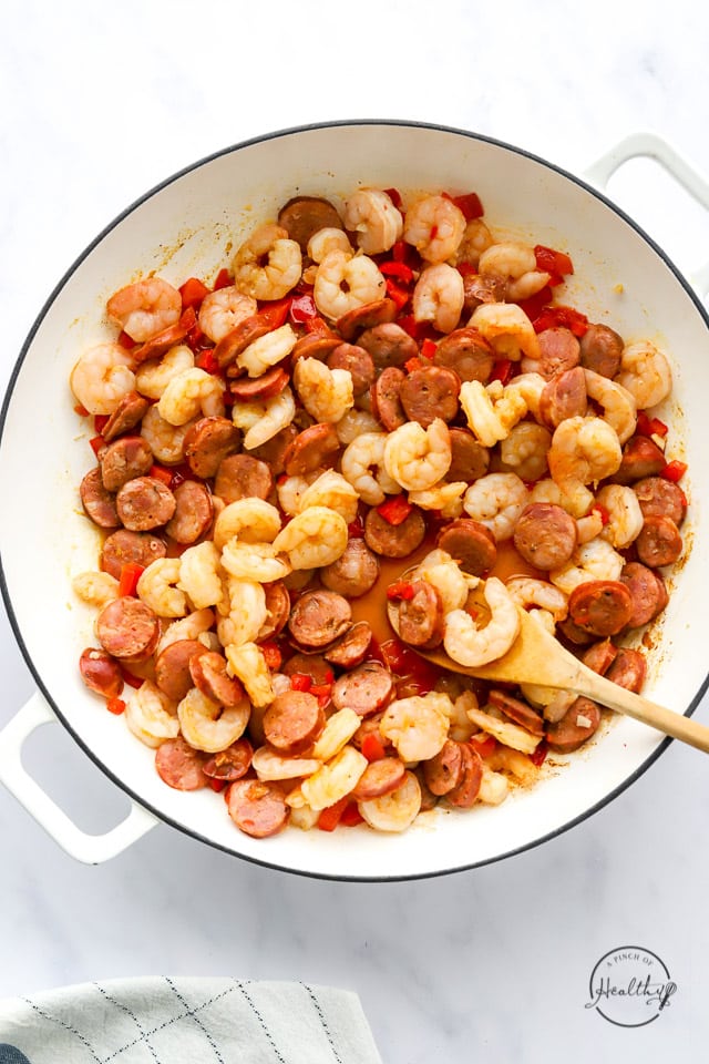 red peppers, sausage and shrimp cooking in a pan