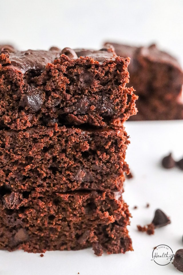 vegan brownies stacked on top of each other on white surface
