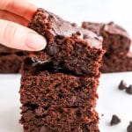 hand reaching for a vegan brownie from the top of stack