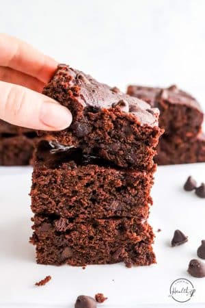 hand reaching for a vegan brownie from the top of stack