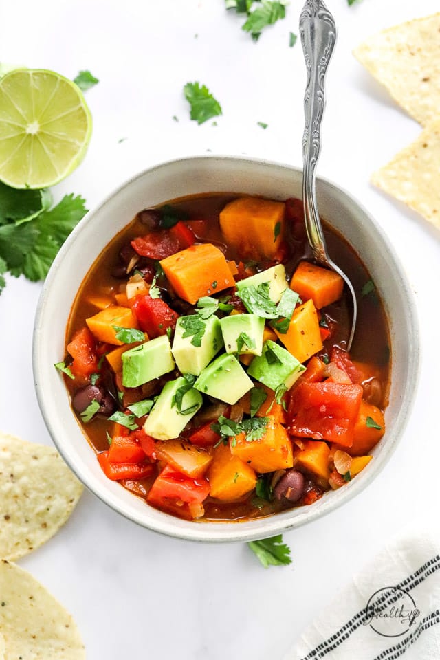 Closeup of Sweet Potato Black Bean Chili in white bowl with spoon