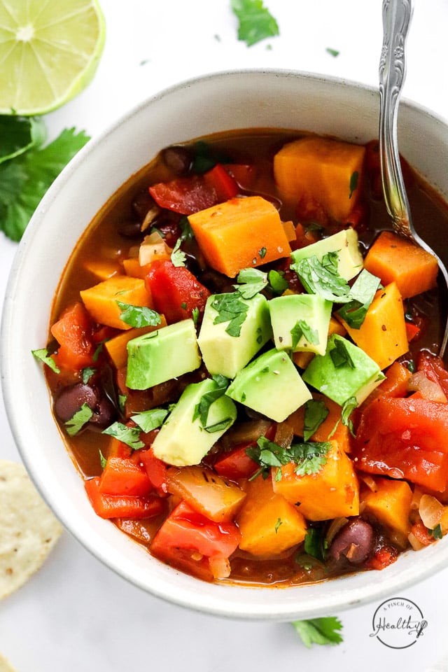 Closeup of Sweet Potato Black Bean Chili in white bowl with spoon