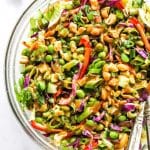 Thai Salad with peanut dressing in serving bowl on white surface