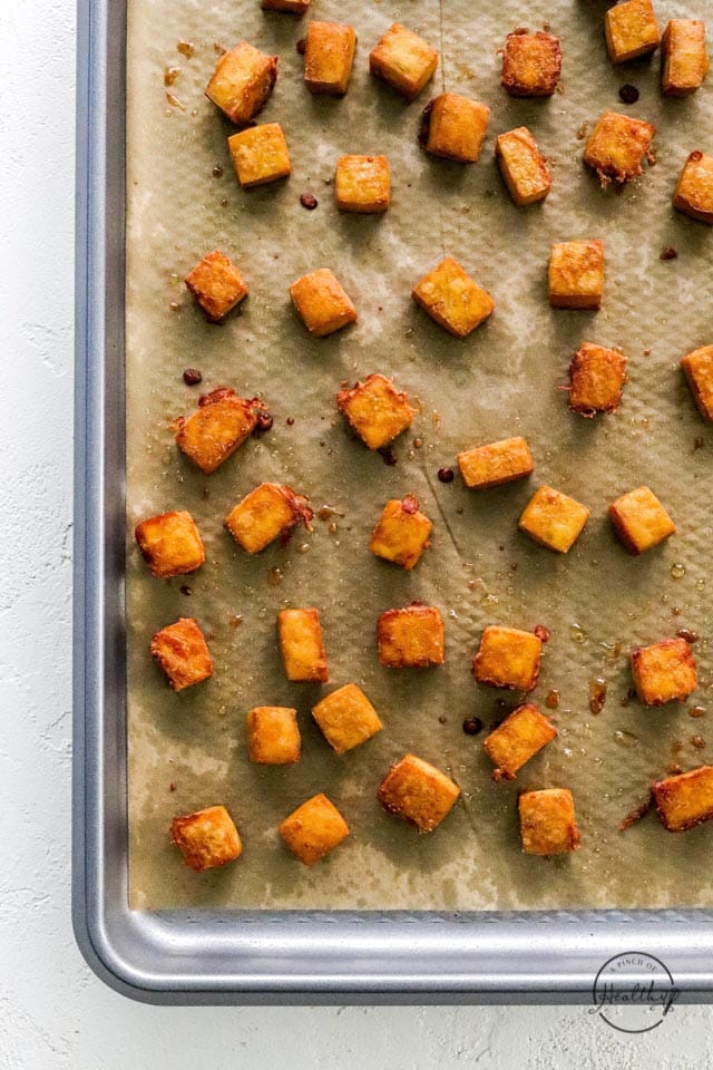 crispy cooked tofu cubes on a baking sheet