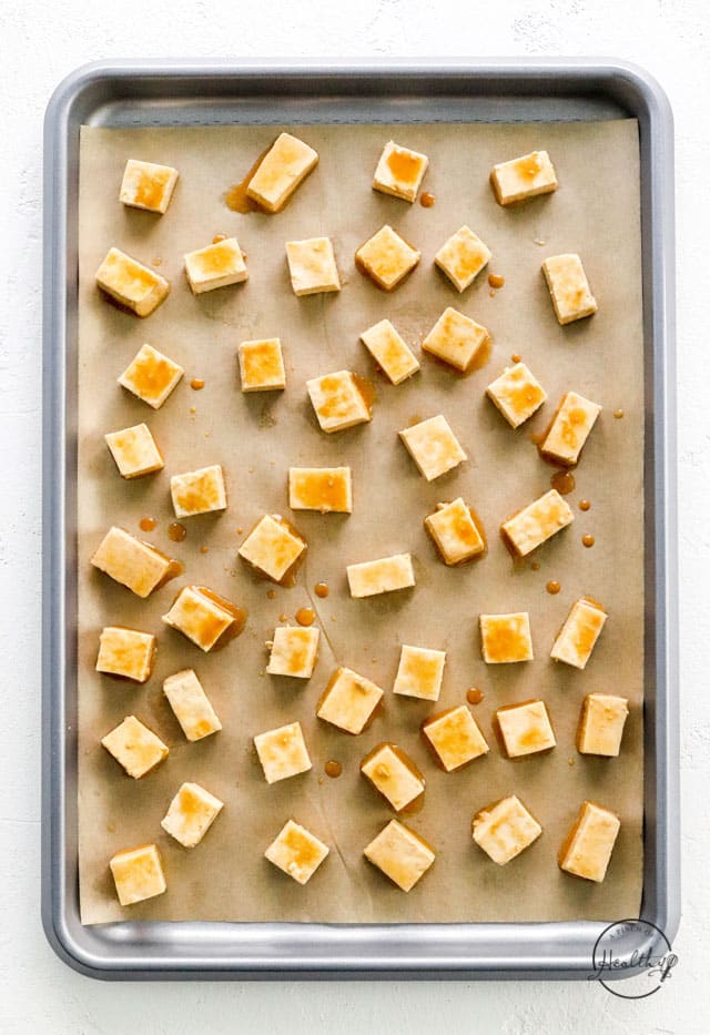 seasoned uncooked tofu cubes on baking sheet