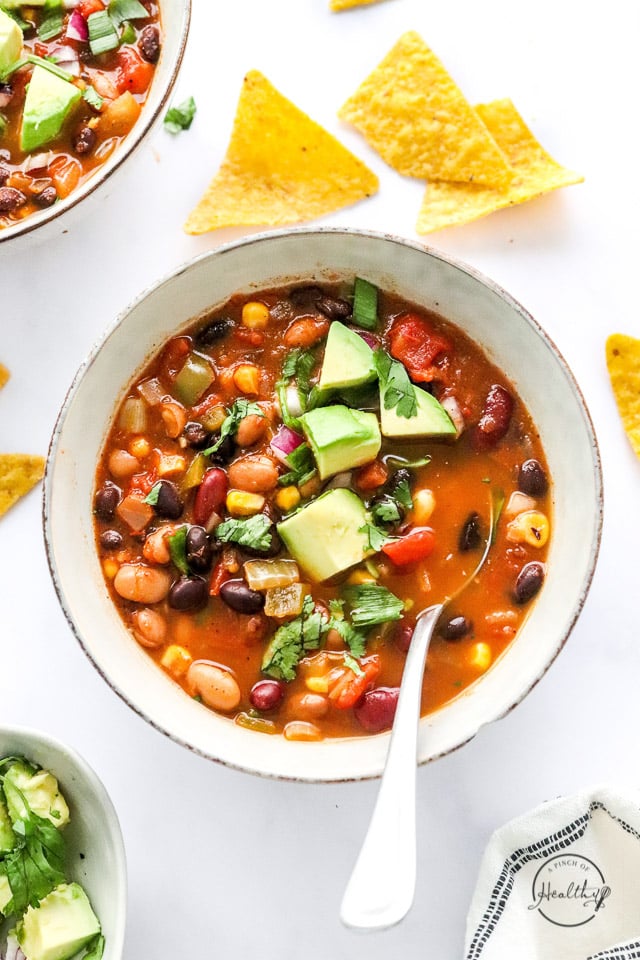 vegan taco soup in a bowl with spoon and tortilla chips