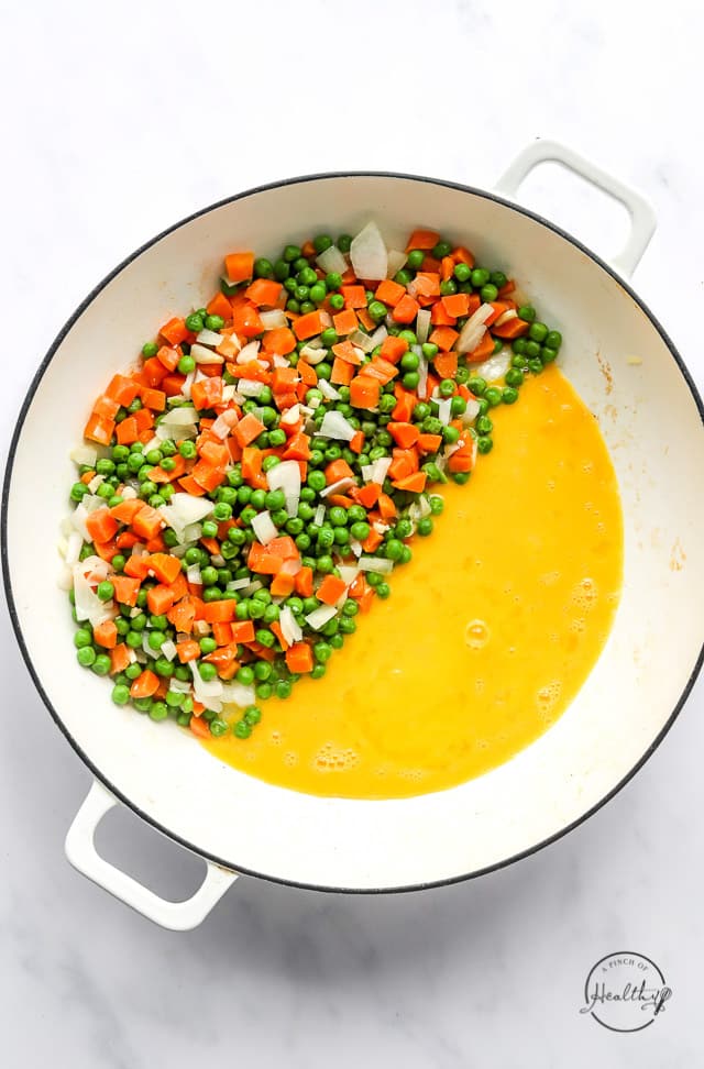 cooking veggies and eggs in a pan