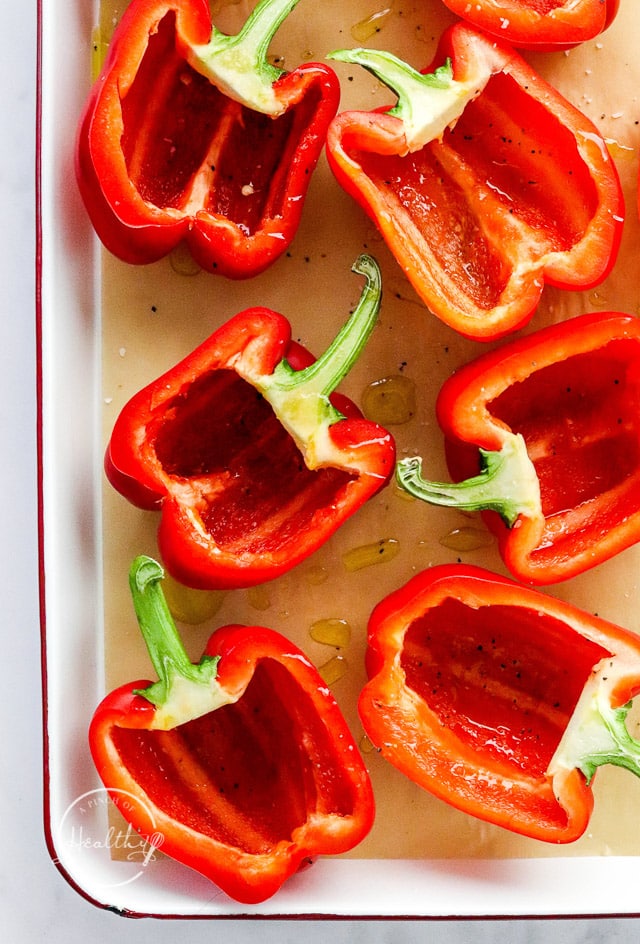 halved peppers on a baking tray