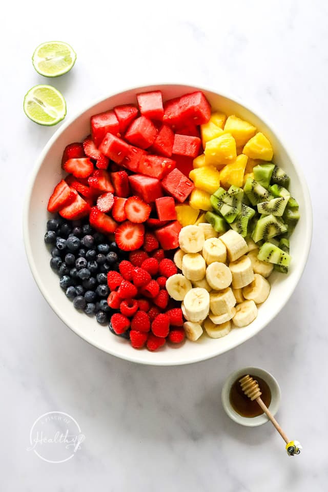 fruit salad ingredients separated in a bowl