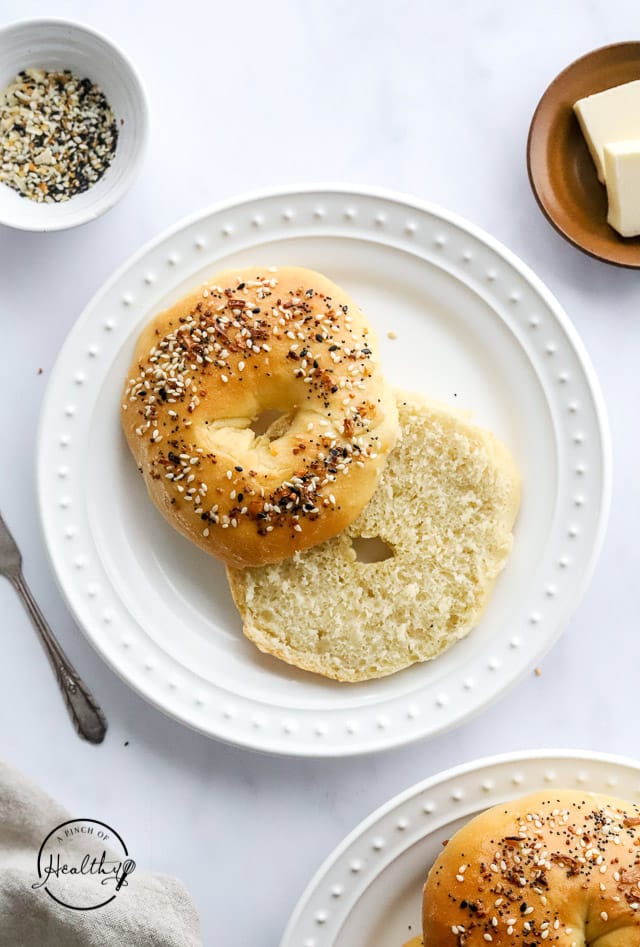 everything bagels on a plate sliced in half