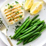 grilled halibut on a plate with green beans
