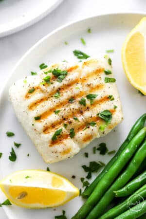 grilled halibut on a plate with green beans
