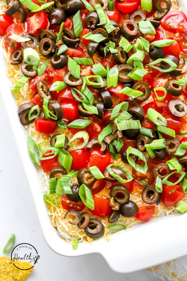 closeup of 7 layer dip in a white casserole dish