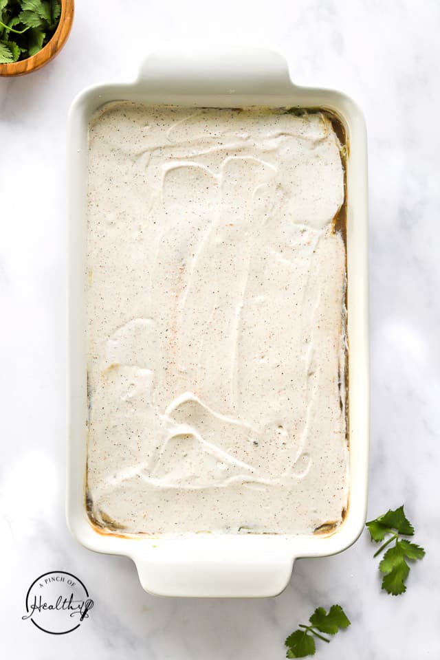 layering on sour cream to make 7 layer dip