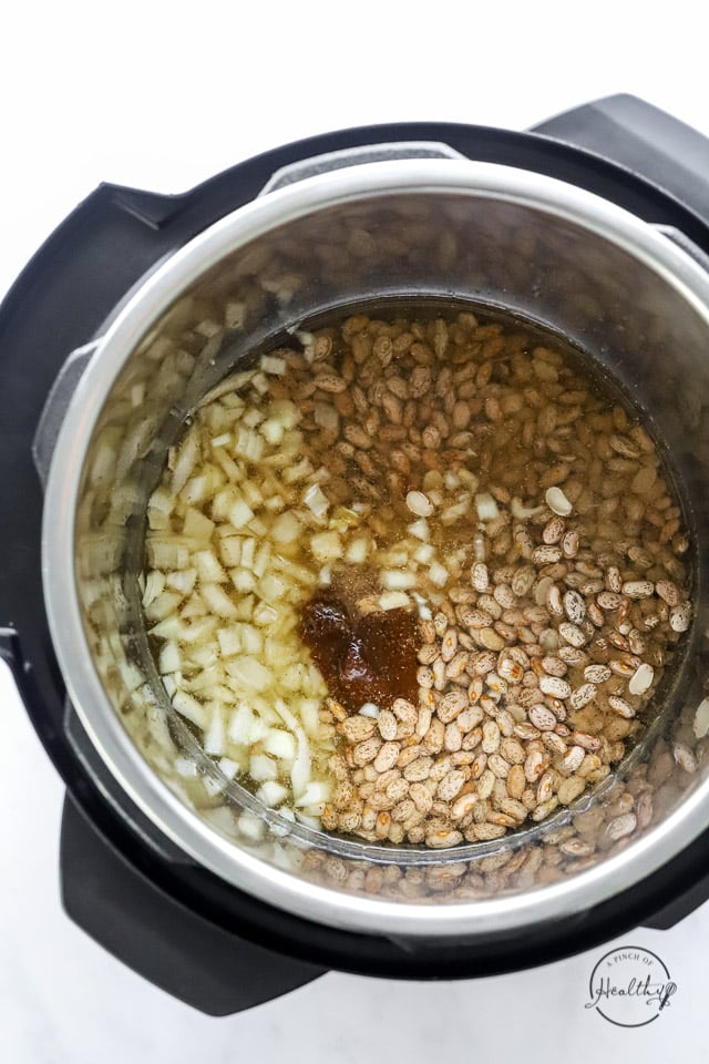 Instant Pot refried bean ingredients in the pot prior to cooking