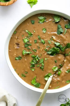 instant pot refried beans in a serving bowl with spoon
