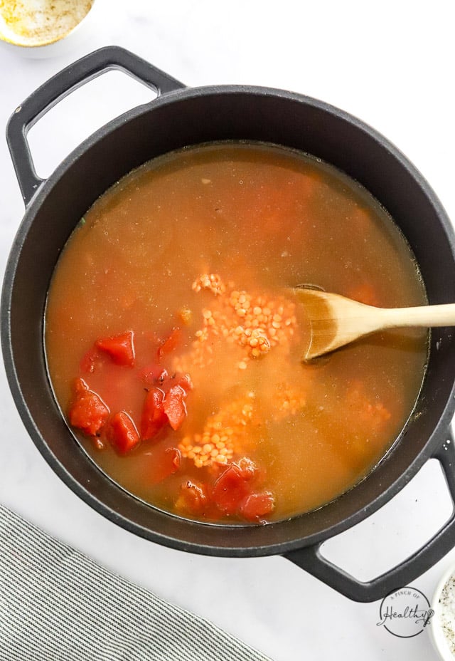 liquid, lentils and tomatoes in a pot