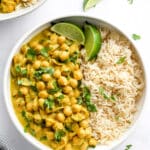 Chickpea Curry with rice in a white bowl with lime slices