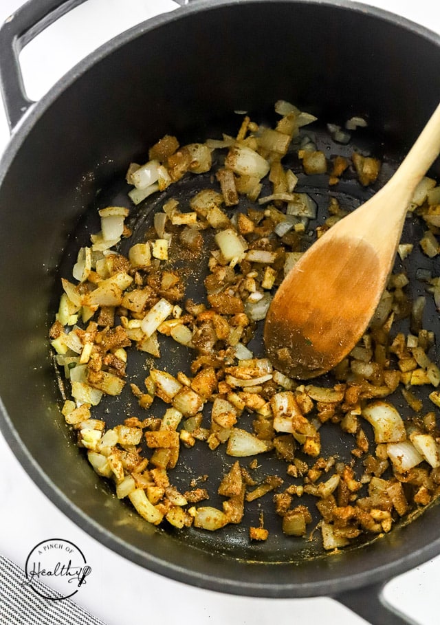 cooking spices with onions in a pot