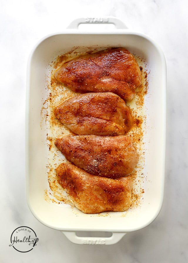 seasoned uncooked chicken in a baking dish