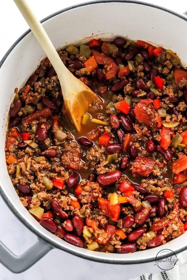 vegan chili in a pot with wooden spoon