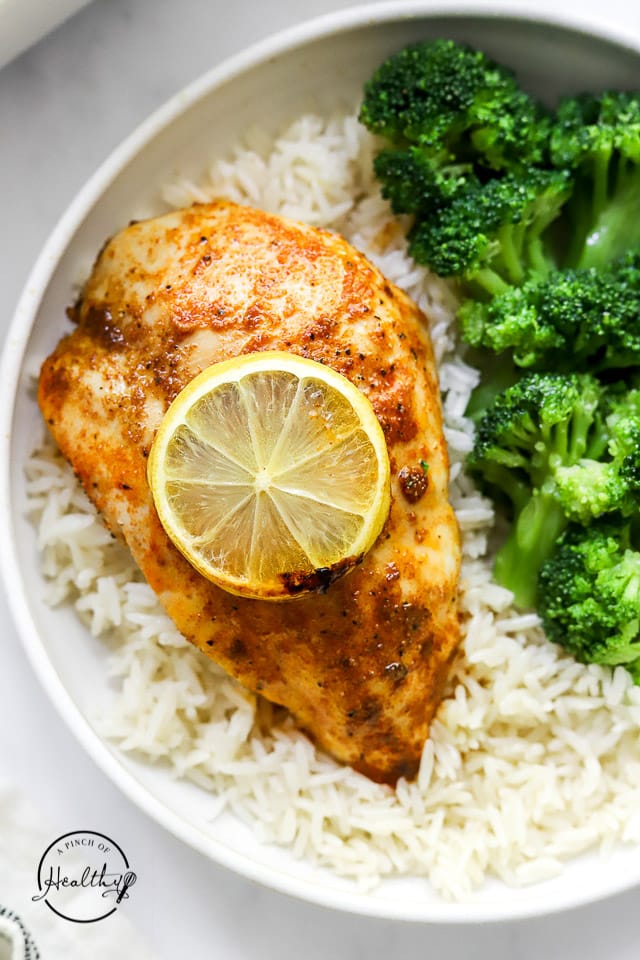 styled baked chicken breast on a plate with rice and broccoli