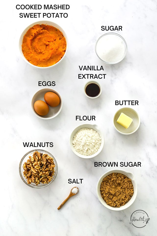 Ingredients for sweet potato casserole in separate containers on a marble background.