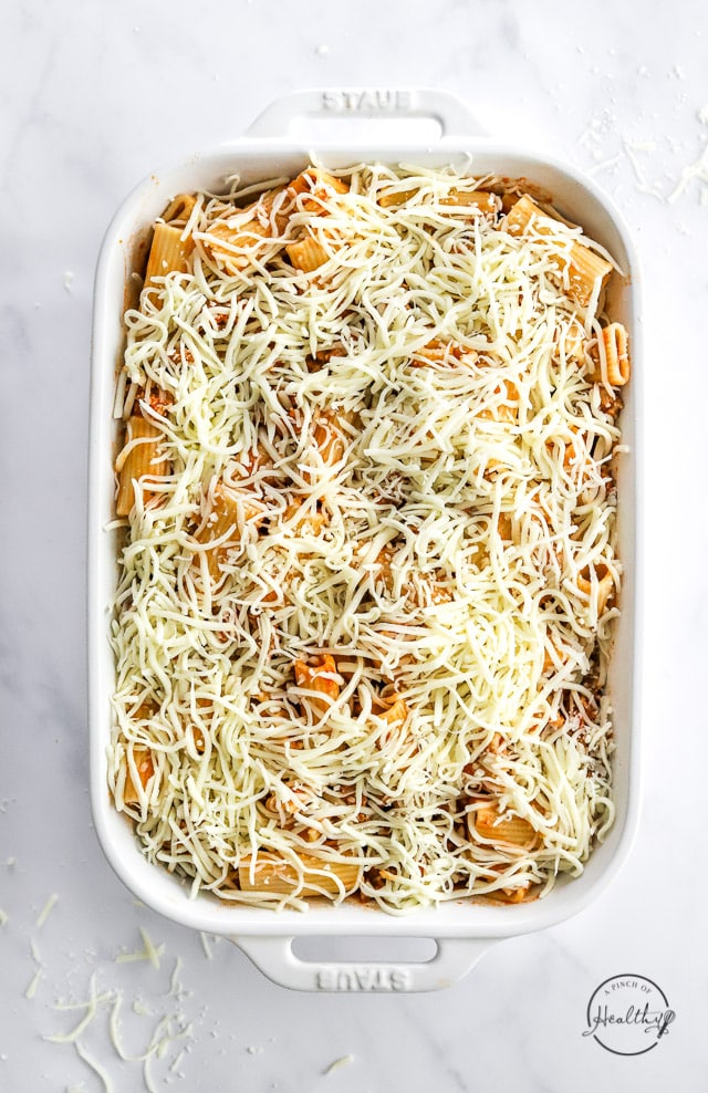 uncooked baked rigatoni topped with cheese