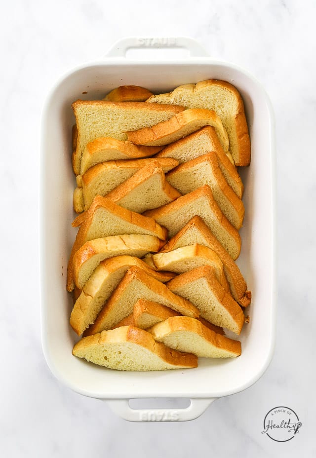 layering bread slices in a baking dish
