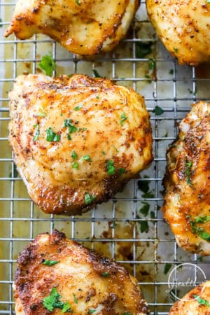 closeup shot of baked chicken thighs on baking sheet