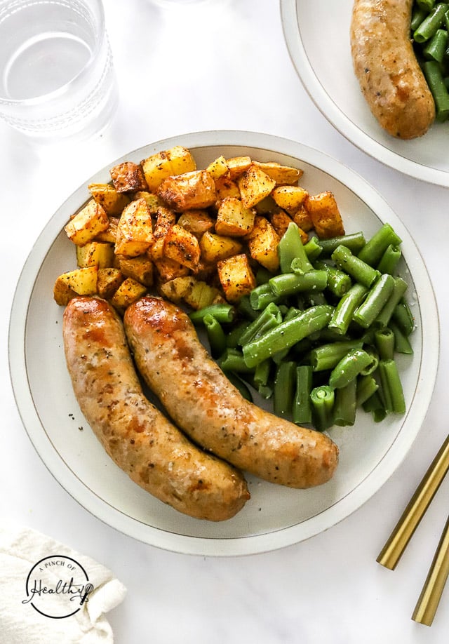 Air Fryer Bratwurst on a plate with roasted potatoes and green beans