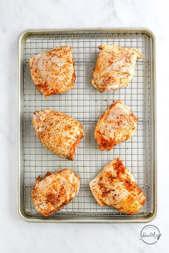 uncooked chicken thighs on a baking sheet