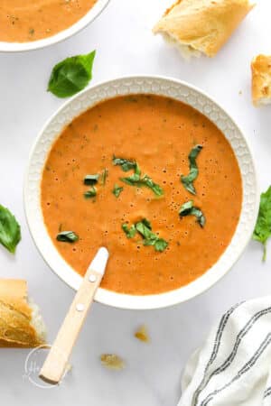 Vegan Tomato Soup in a white bowl with spoon
