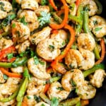 closeup of cast iron pan with shrimp fajitas filling