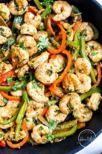 closeup of cast iron pan with shrimp fajitas filling