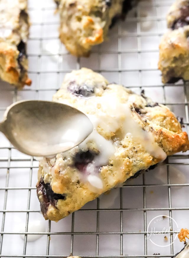 spooning glaze on lemon blueberry scones
