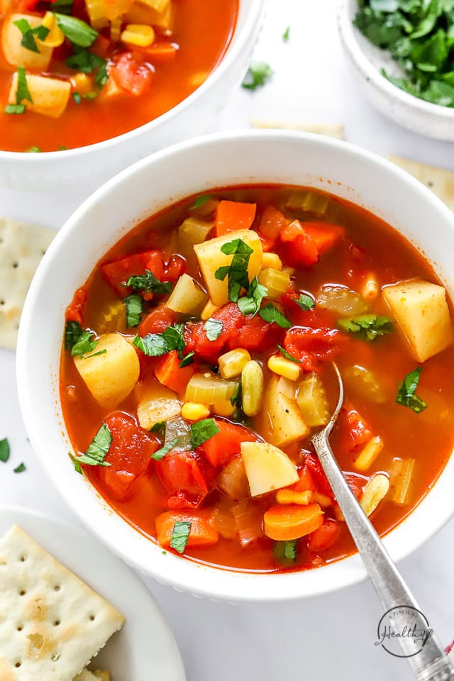 closeup shot of Homemade Vegetable Soup in white bowl with spoon