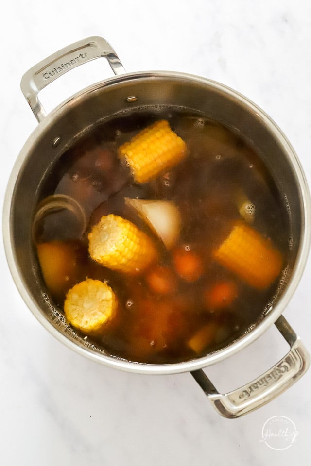 Broth, corn, sausage and potatoes in the pot