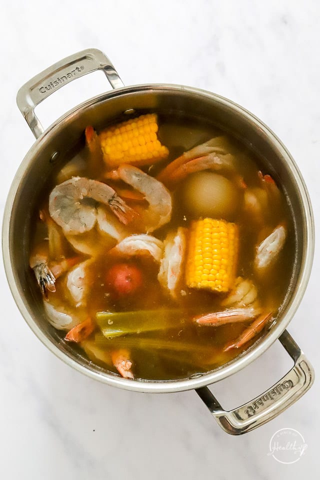 adding shrimp to the pot to make low country boil