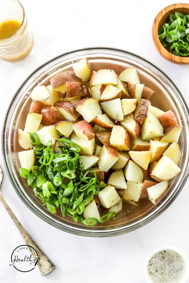 Greek potato salad ingredients in a bowl , separated