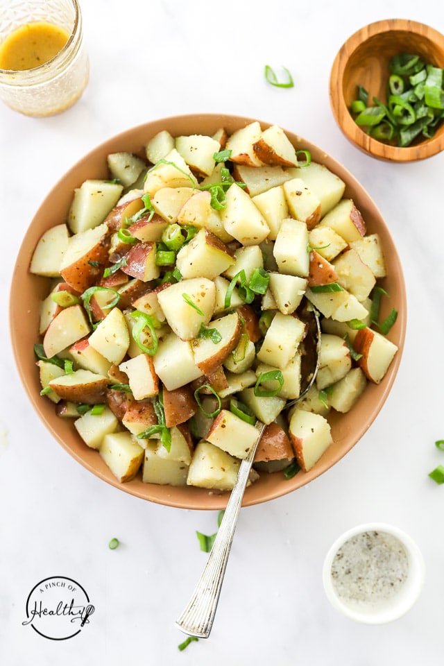 Greek Potato Salad in a serving bowl with spoon
