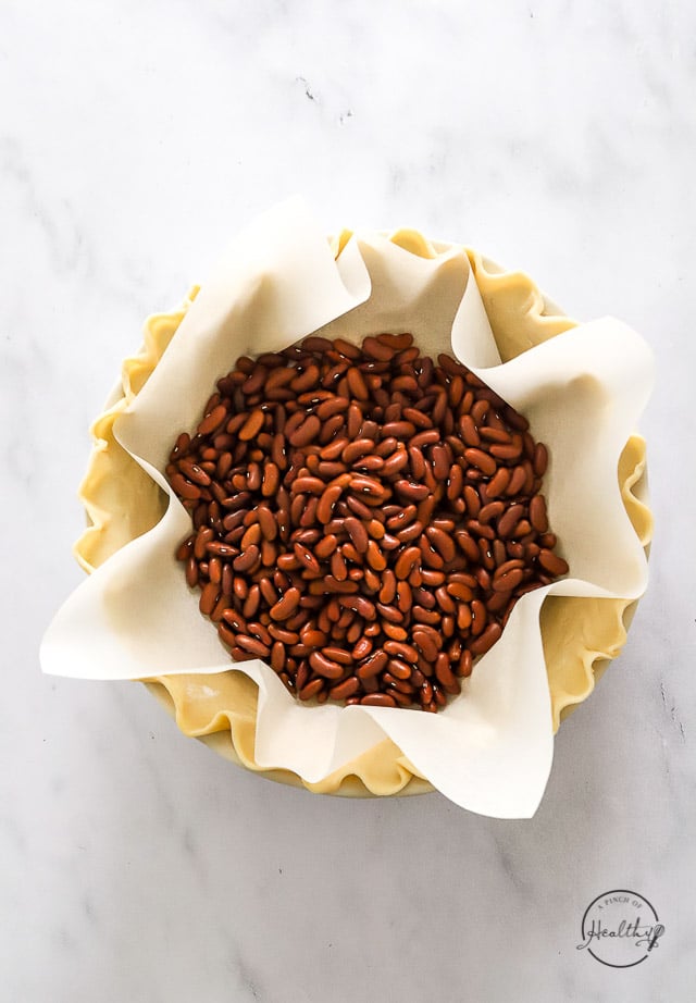 pie crust with parchment and dried beans