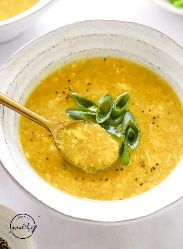 spooning out a bite of egg drop soup