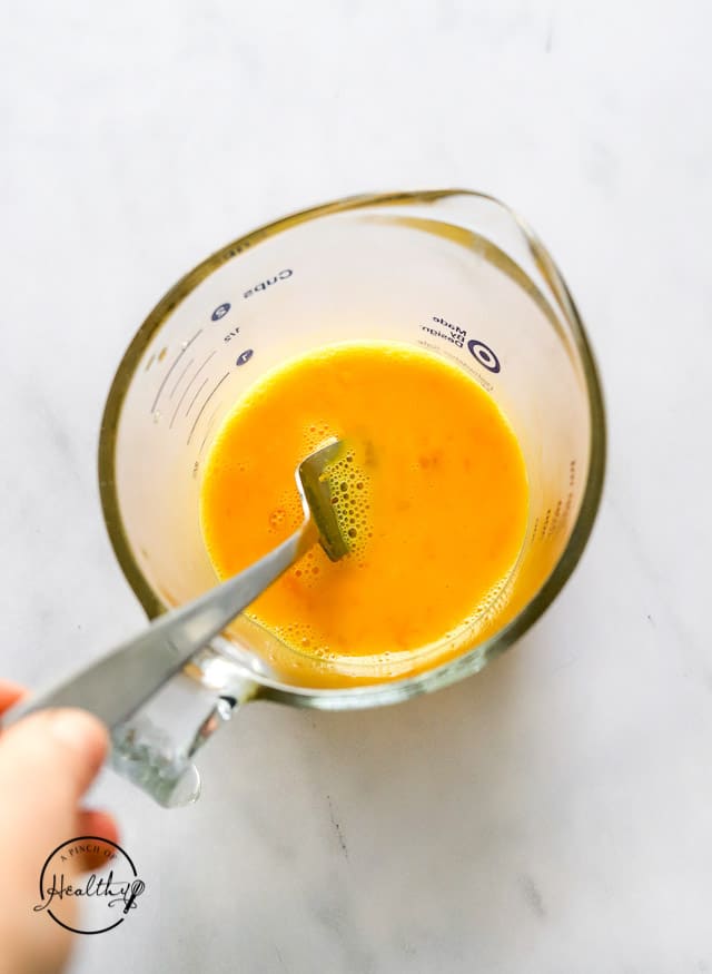 whisking eggs in a measuring bowl