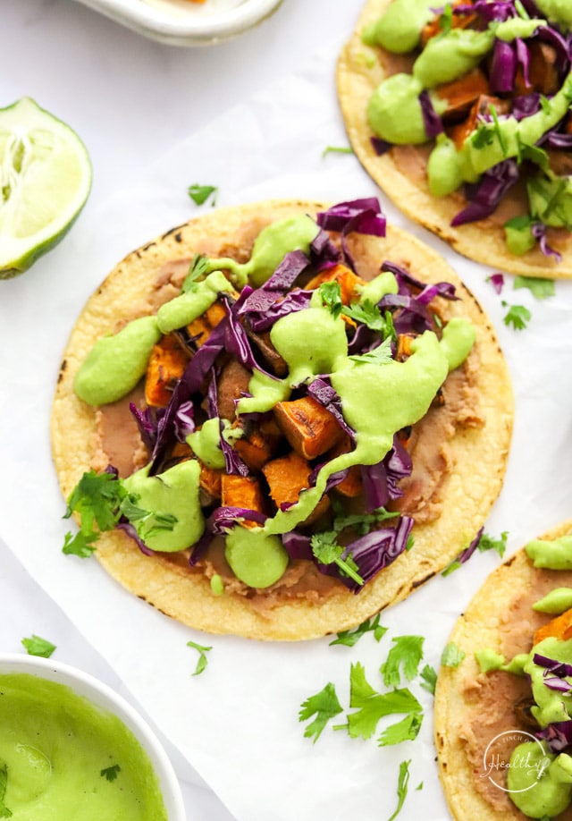 Sweet Potato Tacos with avocado crema on white parchment