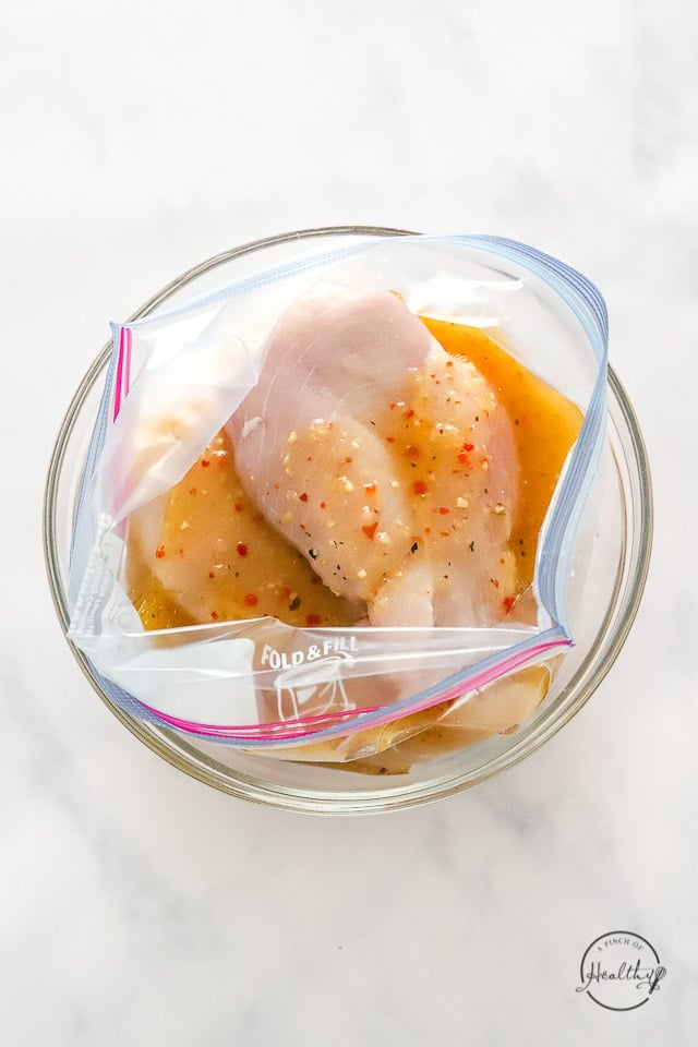 Uncooked chicken in bag with dressing on it
