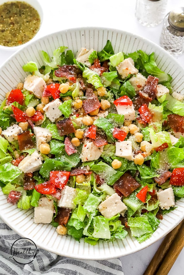 Jennifer Aniston salad in a bowl with wood salad serving utentils