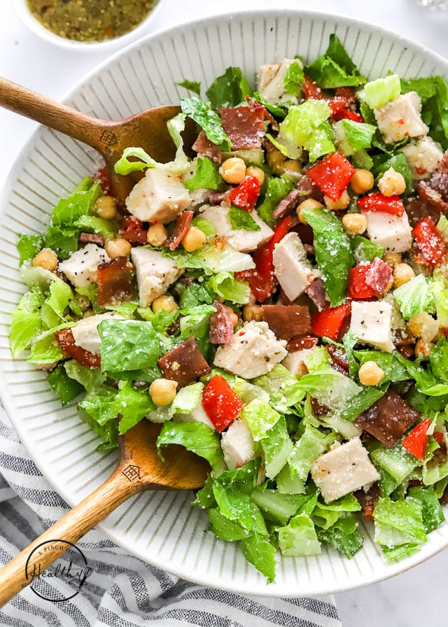 Jennifer Aniston salad in a bowl with wood salad serving utentils